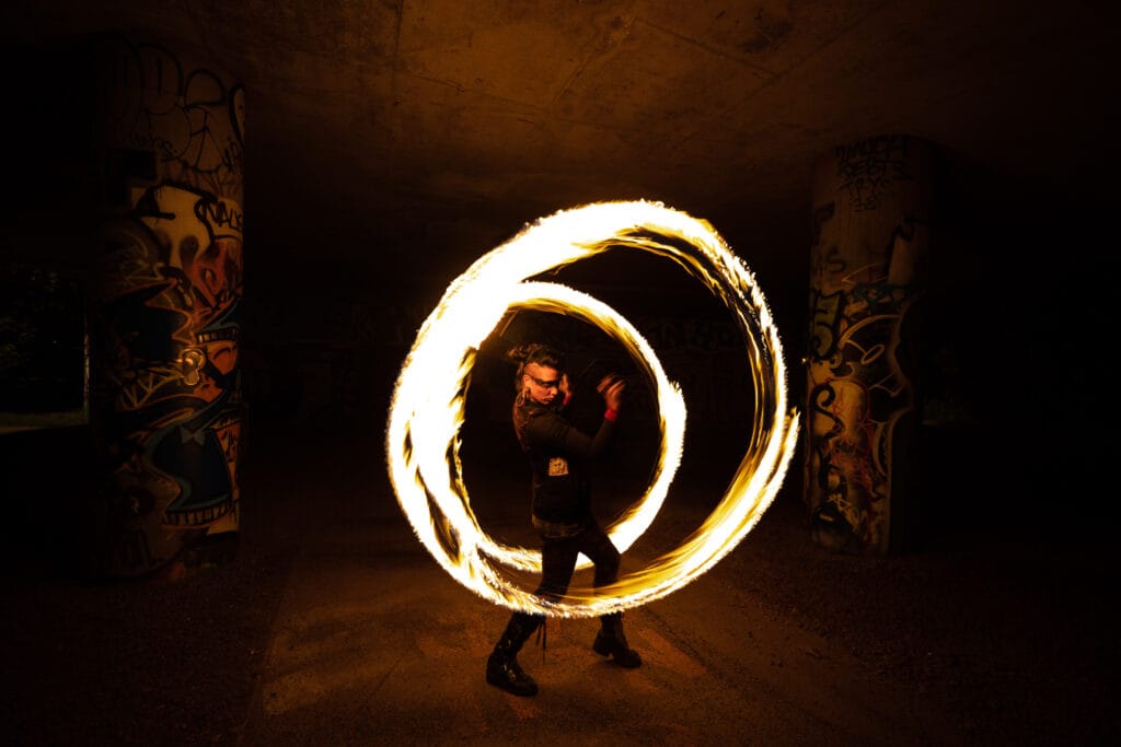 Femme faisant tourner des bolas enflammées lors d'un spectacle de feu